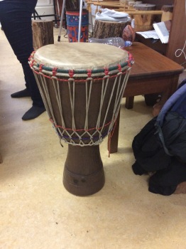 This is a djembe. The top is made of goat skin, and you tighten the top, or the head with the basket of strings around the body of the drum. They are usually handmade in Ghana